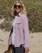 Woman wearing a pastel pink blanket shirt on the beach